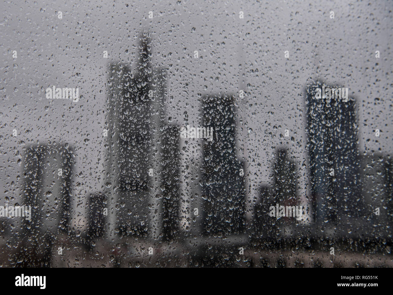 28 Januar 2019, Hessen, Frankfurt/Main: Regen Tropen auf eine Glasscheibe lassen sie die Skyline der Innenstadt in den Hintergrund. Mit Temperaturen wieder Fallenlassen, das Wetter sollte weiterhin seine unbequeme Seite in den kommenden Tagen zeigen. Foto: Boris Roessler/dpa Stockfoto