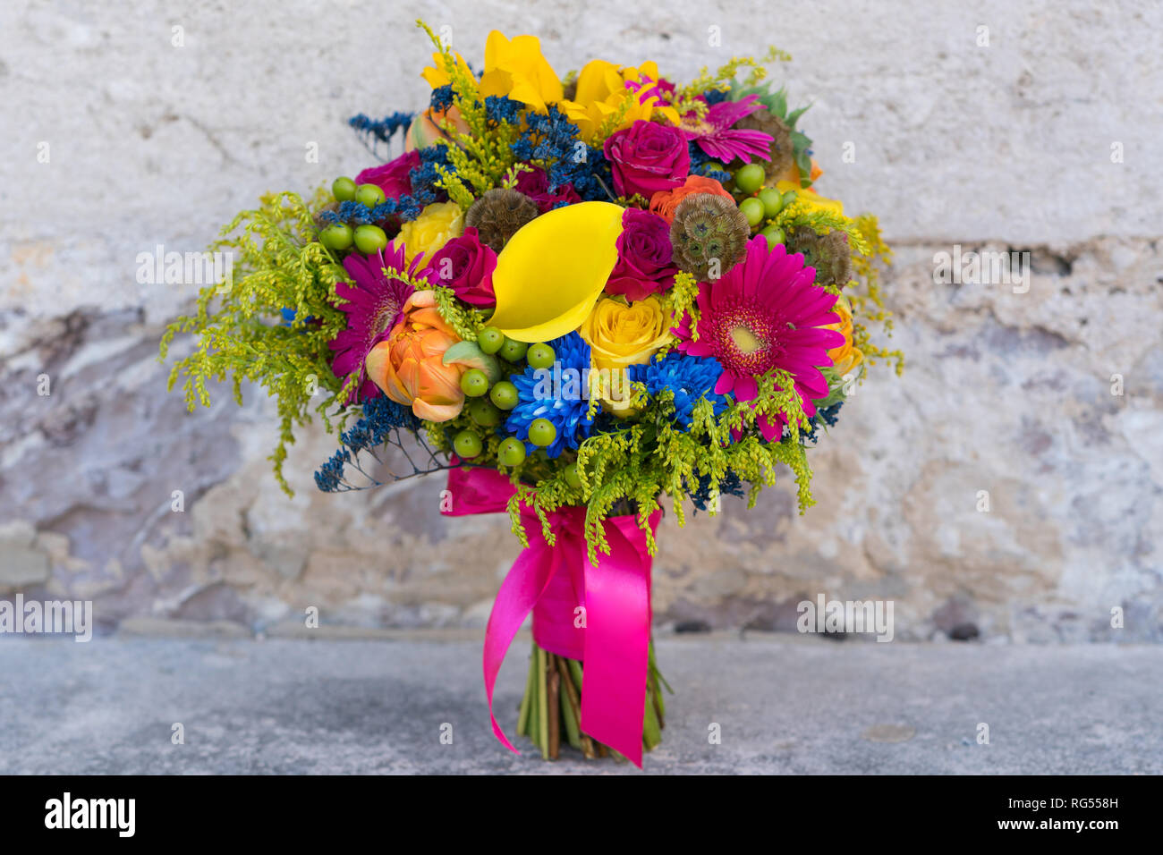 Eine mehrfarbige Wedding Bouquet von frischen Blumen steht auf einem Stein Hintergrund Stockfoto