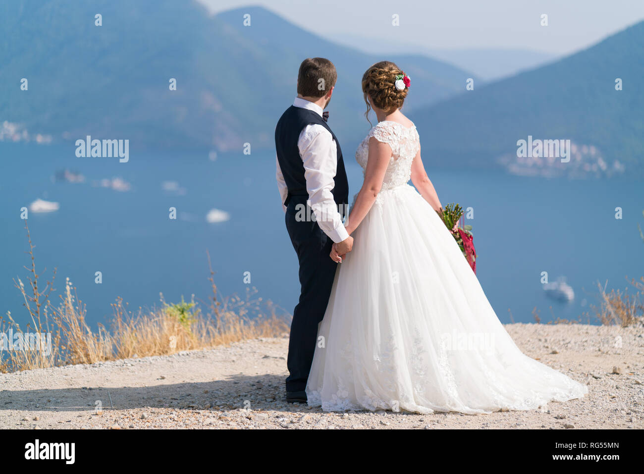 Die Jungvermählten stand auf der Empore und halten sich an den Händen Blick auf das Meer Stockfoto