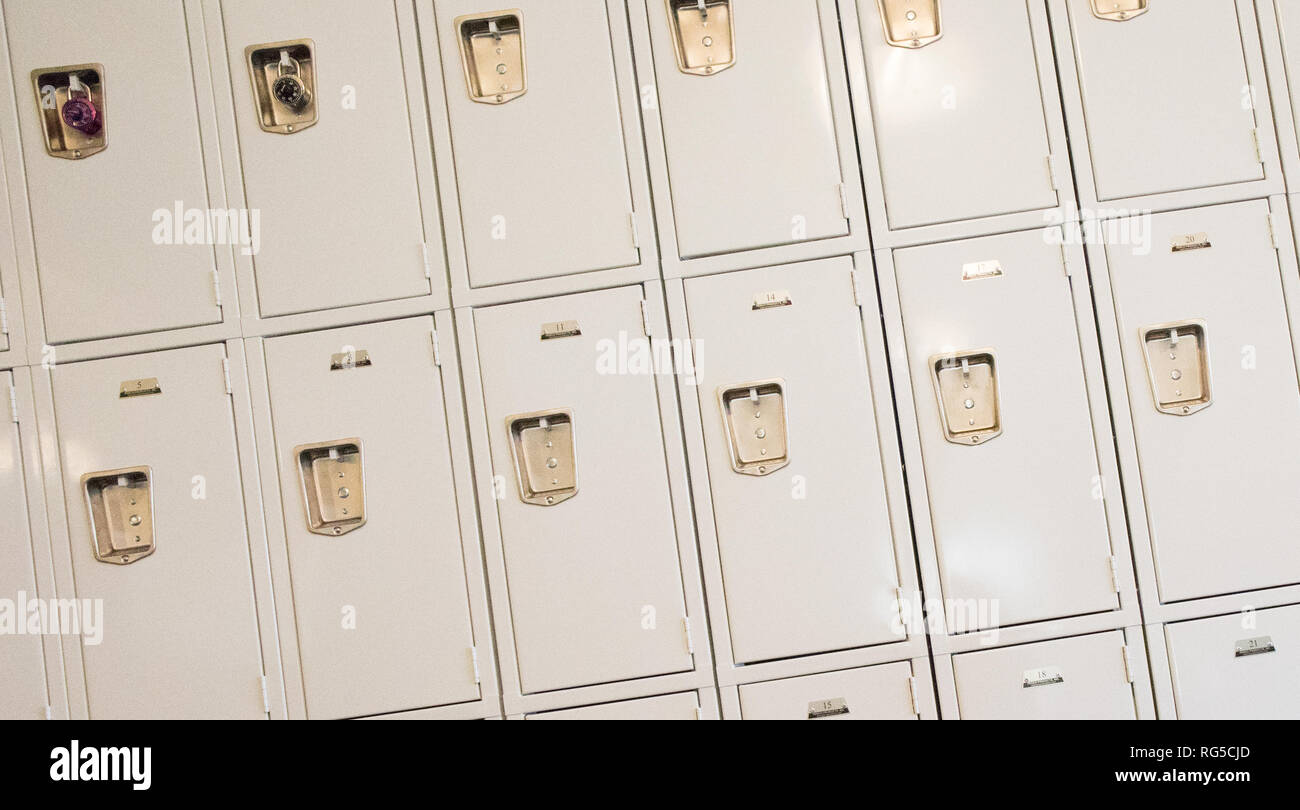 Eine Reihe von Tan Schließfächer mit zwei Vorhängeschlösser in einem pädagogischen Setting. Stockfoto