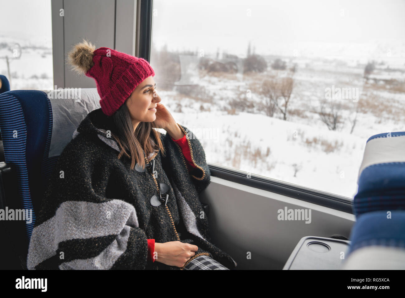 Junge Frau Reisenden im Zug sitzen, Blick durch große Fenster. Stockfoto