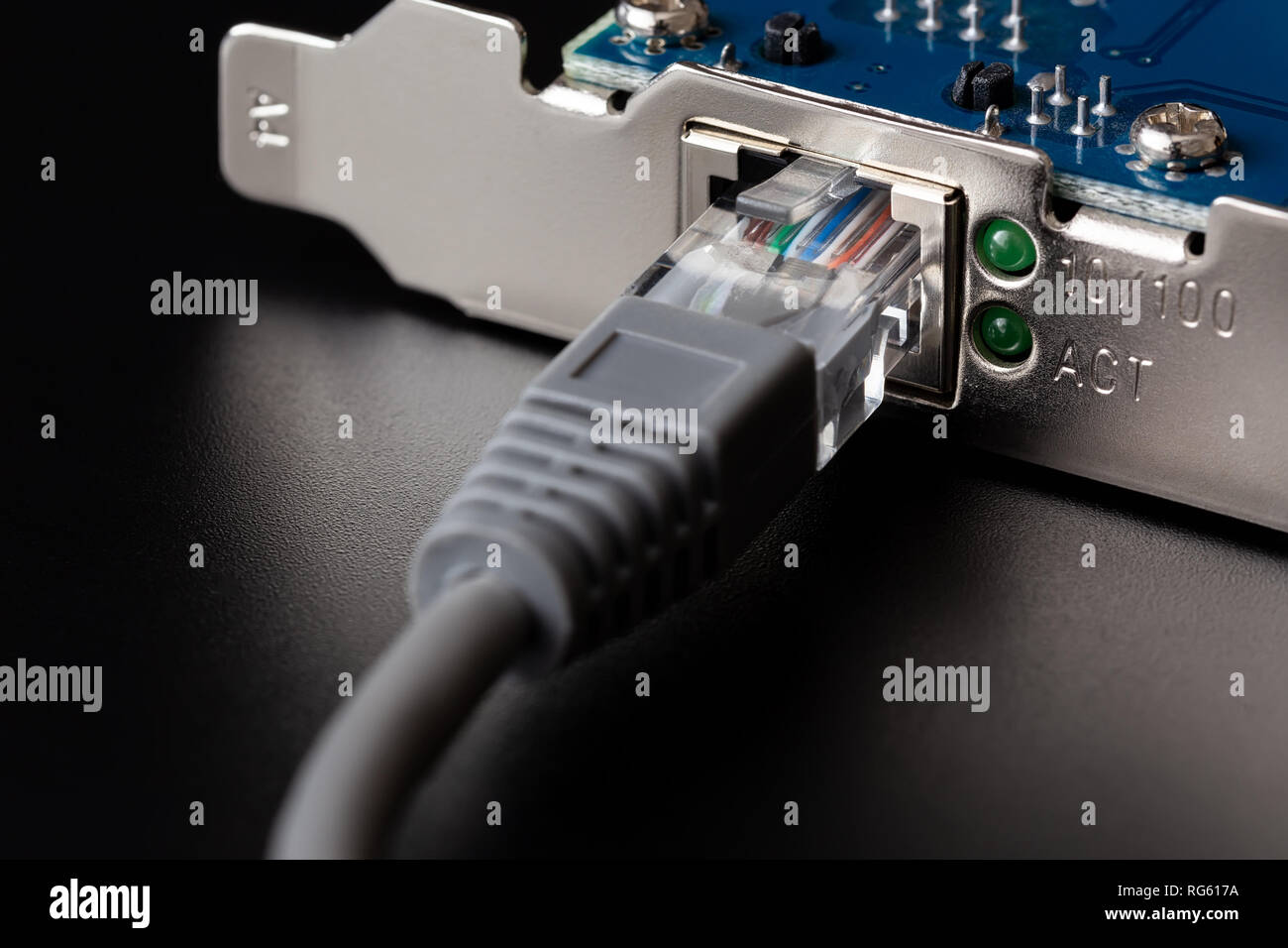 Computer Netzwerkkarte mit angeschlossenem Kabel auf schwarzem Hintergrund Nahaufnahme Stockfoto
