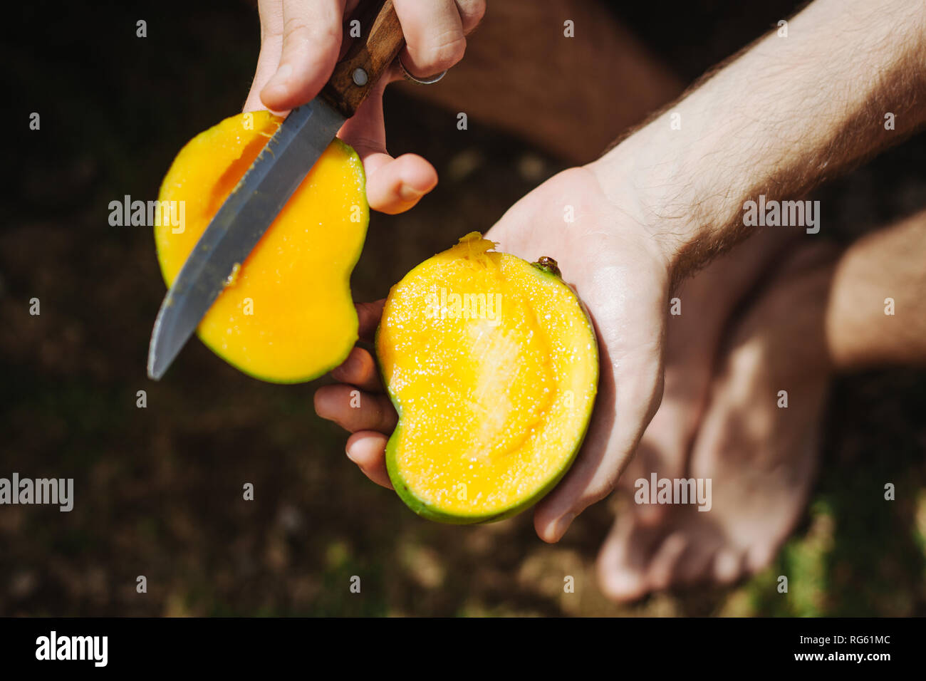 Man Schneiden eine Mango mit Messer, Seychellen Stockfoto