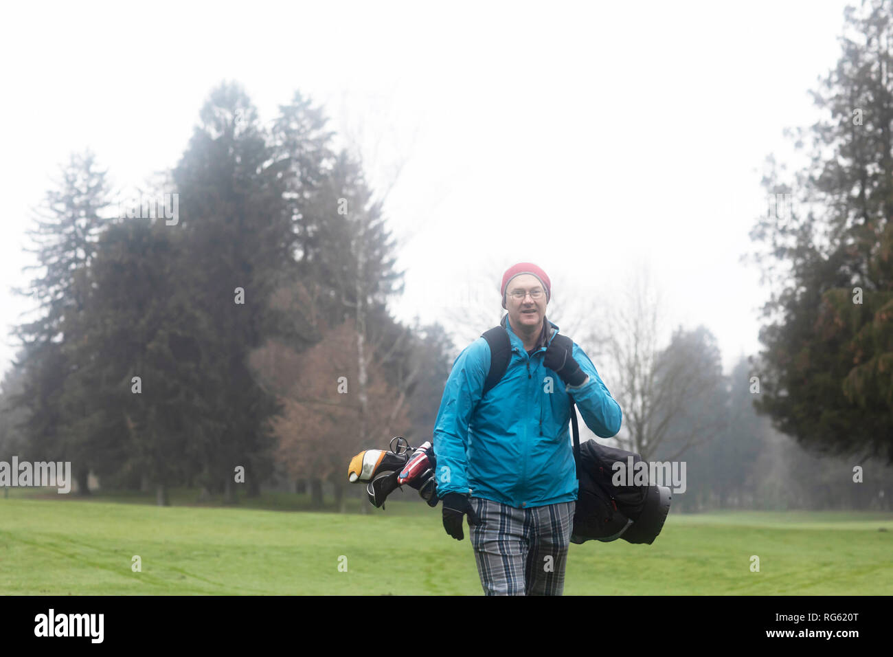 Mann auf einem Golfplatz mit einer Golftasche im Winter, Deutschland Stockfoto