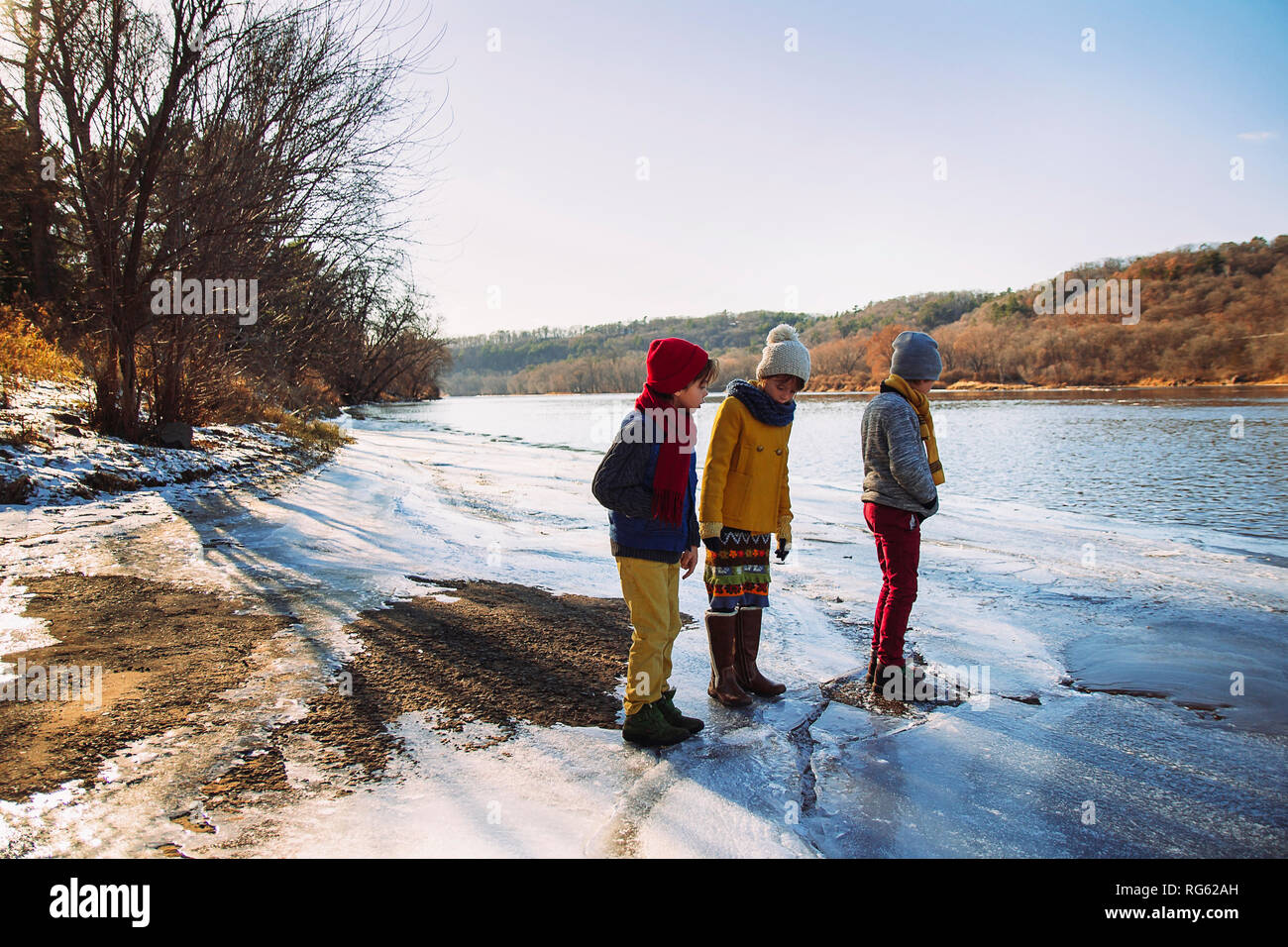 Drei Kinder stehen am Rand einer gefrorenen See, United States Stockfoto