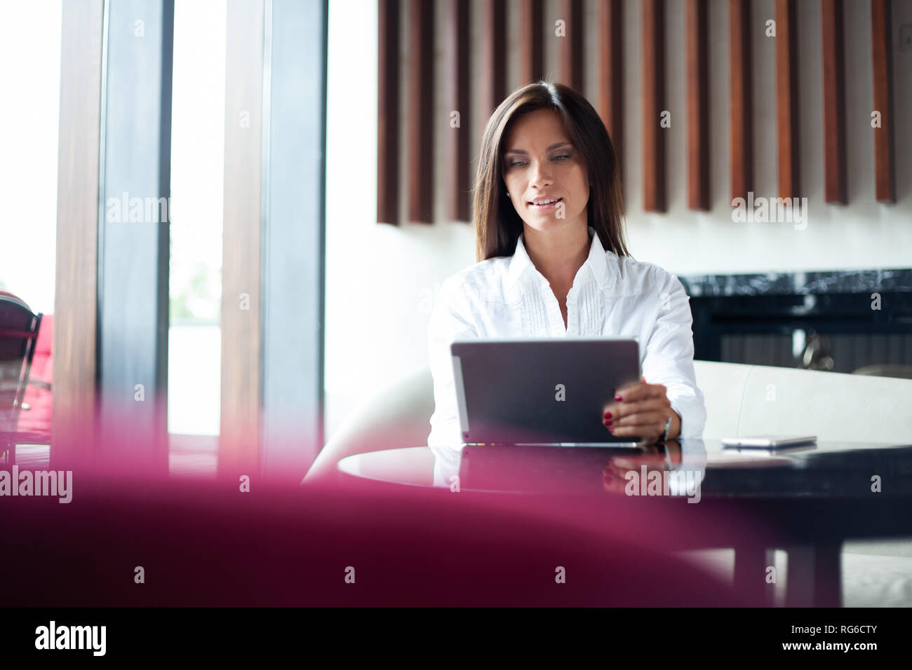Geschäftsfrau trinken Kaffee oder Tee und mit Tablet-PC in einem Coffee Shop. Stockfoto