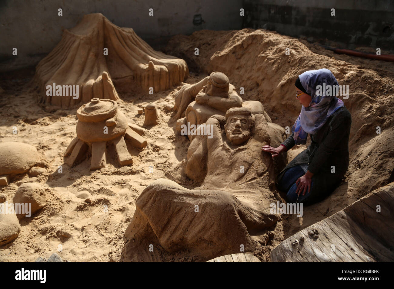 (190128) - GAZA, Jan. 28, 2019 (Xinhua) - Sand Artist Rana Ramlawi arbeitet auf ihrem Sand Skulpturen in Gaza Stadt, Jan. 24, 2019. Rana Ramlawi, ein 23 Jahre alter palästinensischer Junge Frau aus dem Gazastreifen, Erholungsorte auf Sand Kunst die Sache der Palästinenser und die israelisch-palästinensischen Konflikt zu markieren. In ihren Skulpturen aus Sand und Wasser hergestellt, viele Meldungen in Unterstützung der palästinensischen Sache vermittelt, da sie glaubt, dass Kunst ist ein wichtiger Weg, um die Rechte und die Forderung nach Freiheit zu betonen und die Beendigung der israelischen Besatzung. "Eines meiner Ziele in meinen Arbeiten ist dieses Erbe zu bewahren und zu sagen Stockfoto