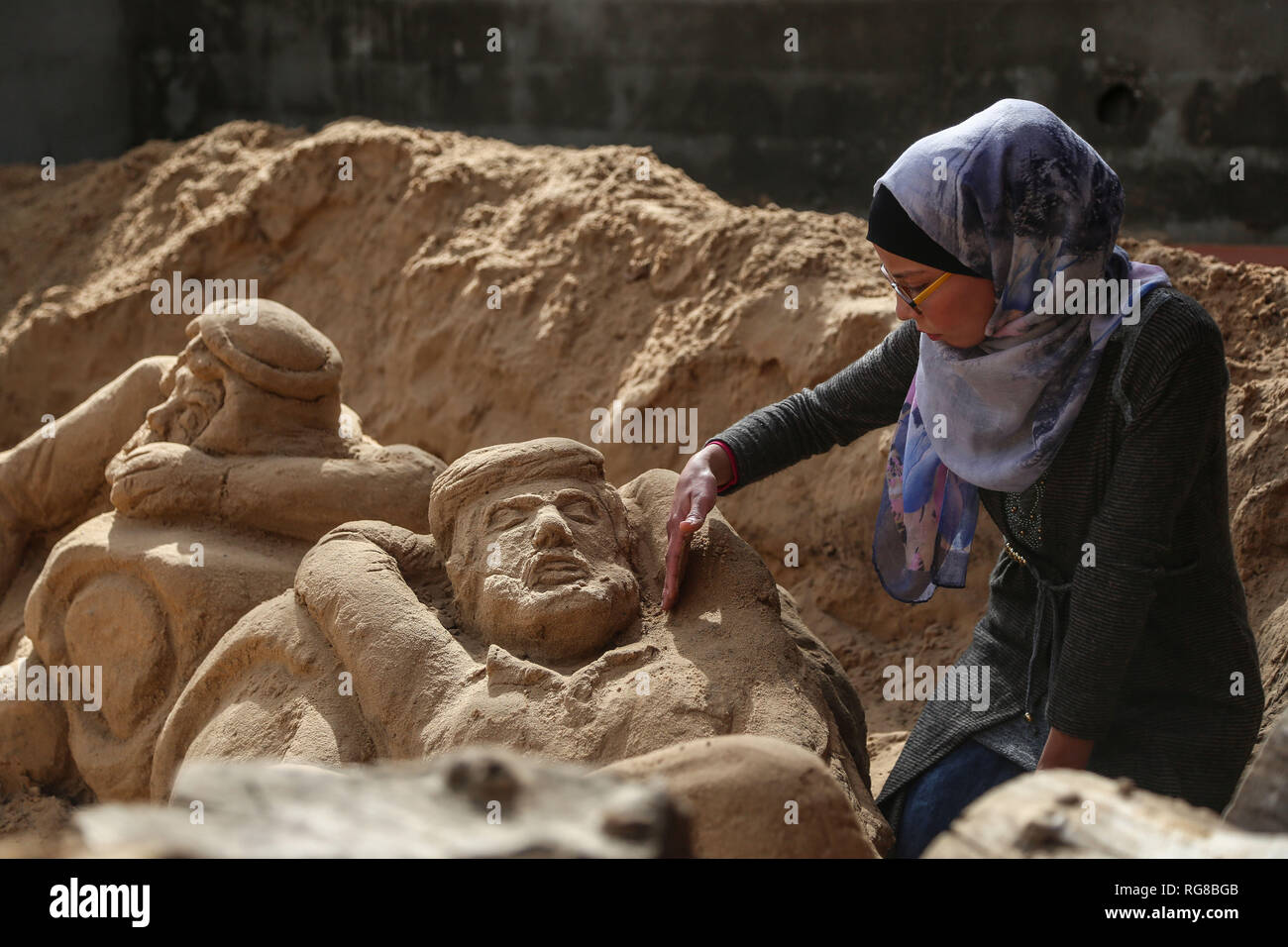 (190128) - GAZA, Jan. 28, 2019 (Xinhua) - Sand Artist Rana Ramlawi arbeitet auf ihrem Sand Skulpturen in Gaza Stadt, Jan. 24, 2019. Rana Ramlawi, ein 23 Jahre alter palästinensischer Junge Frau aus dem Gazastreifen, Erholungsorte auf Sand Kunst die Sache der Palästinenser und die israelisch-palästinensischen Konflikt zu markieren. In ihren Skulpturen aus Sand und Wasser hergestellt, viele Meldungen in Unterstützung der palästinensischen Sache vermittelt, da sie glaubt, dass Kunst ist ein wichtiger Weg, um die Rechte und die Forderung nach Freiheit zu betonen und die Beendigung der israelischen Besatzung. "Eines meiner Ziele in meinen Arbeiten ist dieses Erbe zu bewahren und zu sagen Stockfoto