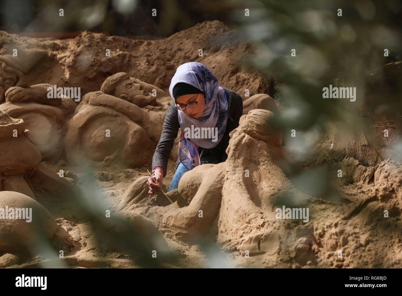 (190128) - GAZA, Jan. 28, 2019 (Xinhua) - Sand Artist Rana Ramlawi arbeitet auf ihrem Sand Skulpturen in Gaza Stadt, Jan. 24, 2019. Rana Ramlawi, ein 23 Jahre alter palästinensischer Junge Frau aus dem Gazastreifen, Erholungsorte auf Sand Kunst die Sache der Palästinenser und die israelisch-palästinensischen Konflikt zu markieren. In ihren Skulpturen aus Sand und Wasser hergestellt, viele Meldungen in Unterstützung der palästinensischen Sache vermittelt, da sie glaubt, dass Kunst ist ein wichtiger Weg, um die Rechte und die Forderung nach Freiheit zu betonen und die Beendigung der israelischen Besatzung. "Eines meiner Ziele in meinen Arbeiten ist dieses Erbe zu bewahren und zu sagen Stockfoto