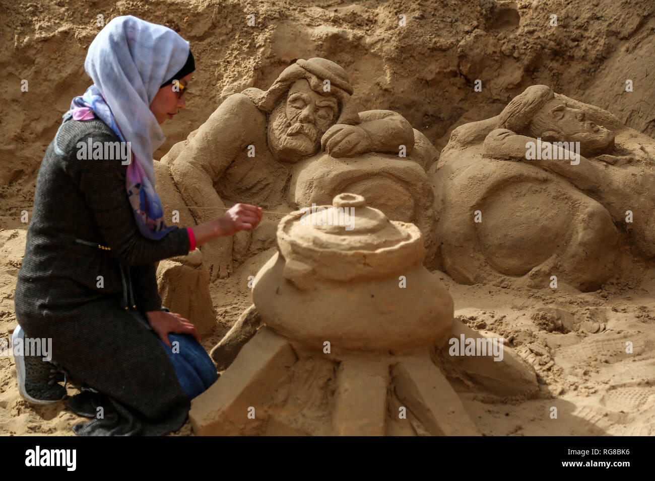 (190128) - GAZA, Jan. 28, 2019 (Xinhua) - Sand Artist Rana Ramlawi arbeitet auf ihrem Sand Skulpturen in Gaza Stadt, Jan. 24, 2019. Rana Ramlawi, ein 23 Jahre alter palästinensischer Junge Frau aus dem Gazastreifen, Erholungsorte auf Sand Kunst die Sache der Palästinenser und die israelisch-palästinensischen Konflikt zu markieren. In ihren Skulpturen aus Sand und Wasser hergestellt, viele Meldungen in Unterstützung der palästinensischen Sache vermittelt, da sie glaubt, dass Kunst ist ein wichtiger Weg, um die Rechte und die Forderung nach Freiheit zu betonen und die Beendigung der israelischen Besatzung. "Eines meiner Ziele in meinen Arbeiten ist dieses Erbe zu bewahren und zu sagen Stockfoto