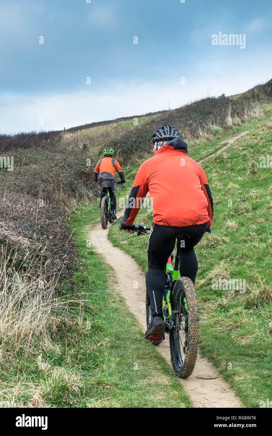 Zwei Mountainbiker Radeln entlang ein Fußweg an der Küste von Cornwall. Stockfoto