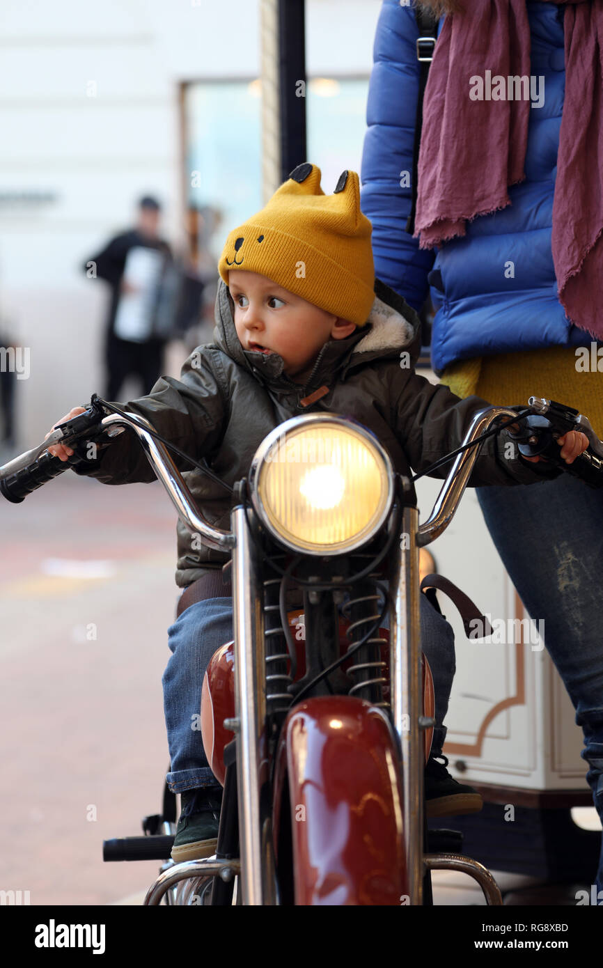 Cute Baby Junge sitzt auf einem Oldtimer Motorrad, der kleine Junge auf dem  Karussell, Nahaufnahme, Porträt Stockfotografie - Alamy