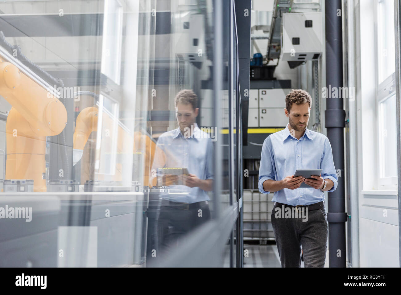 Unternehmer prüfen Roboter mit digitalen Tablet in High-Tech-Unternehmen Stockfoto