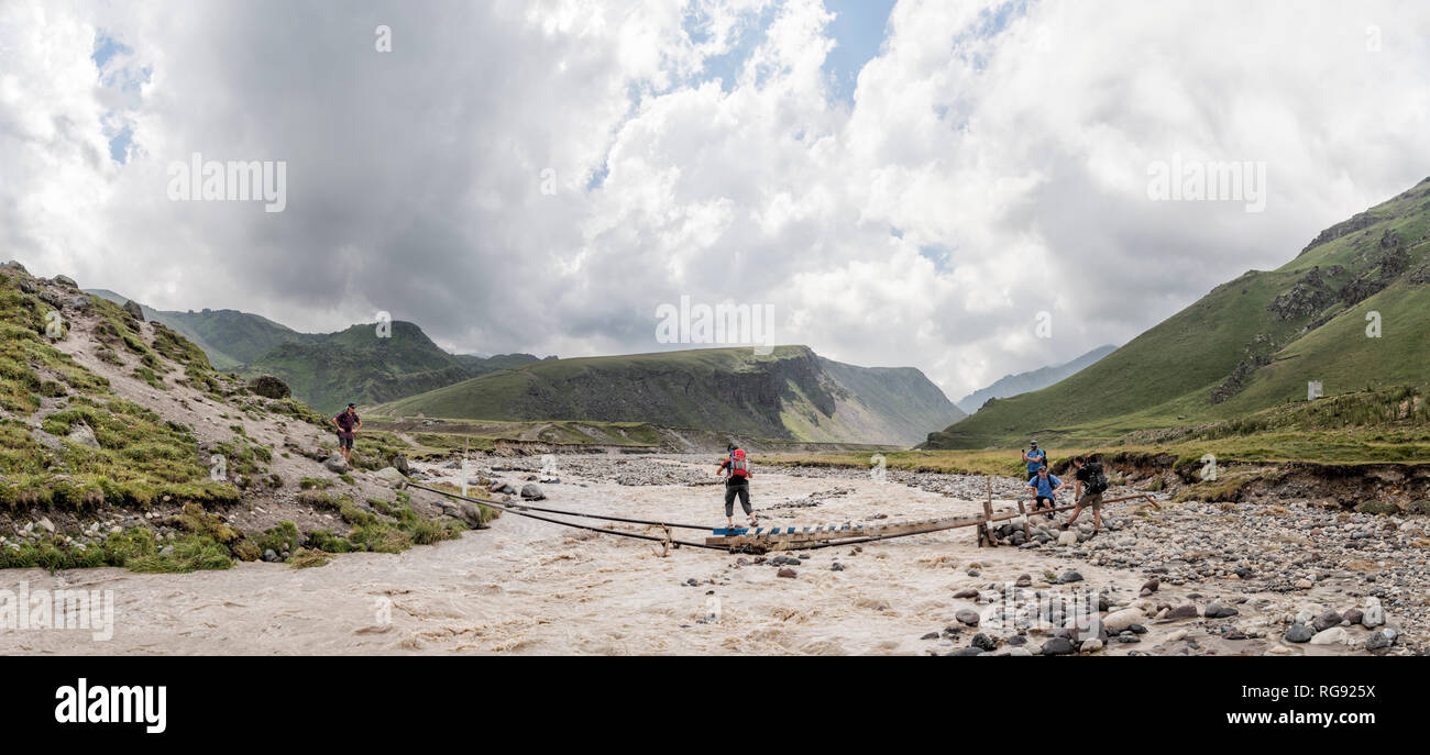 Russland, Kaukasus, Bergsteiger Überquerung des Flusses in der oberen Baksan Tal Stockfoto