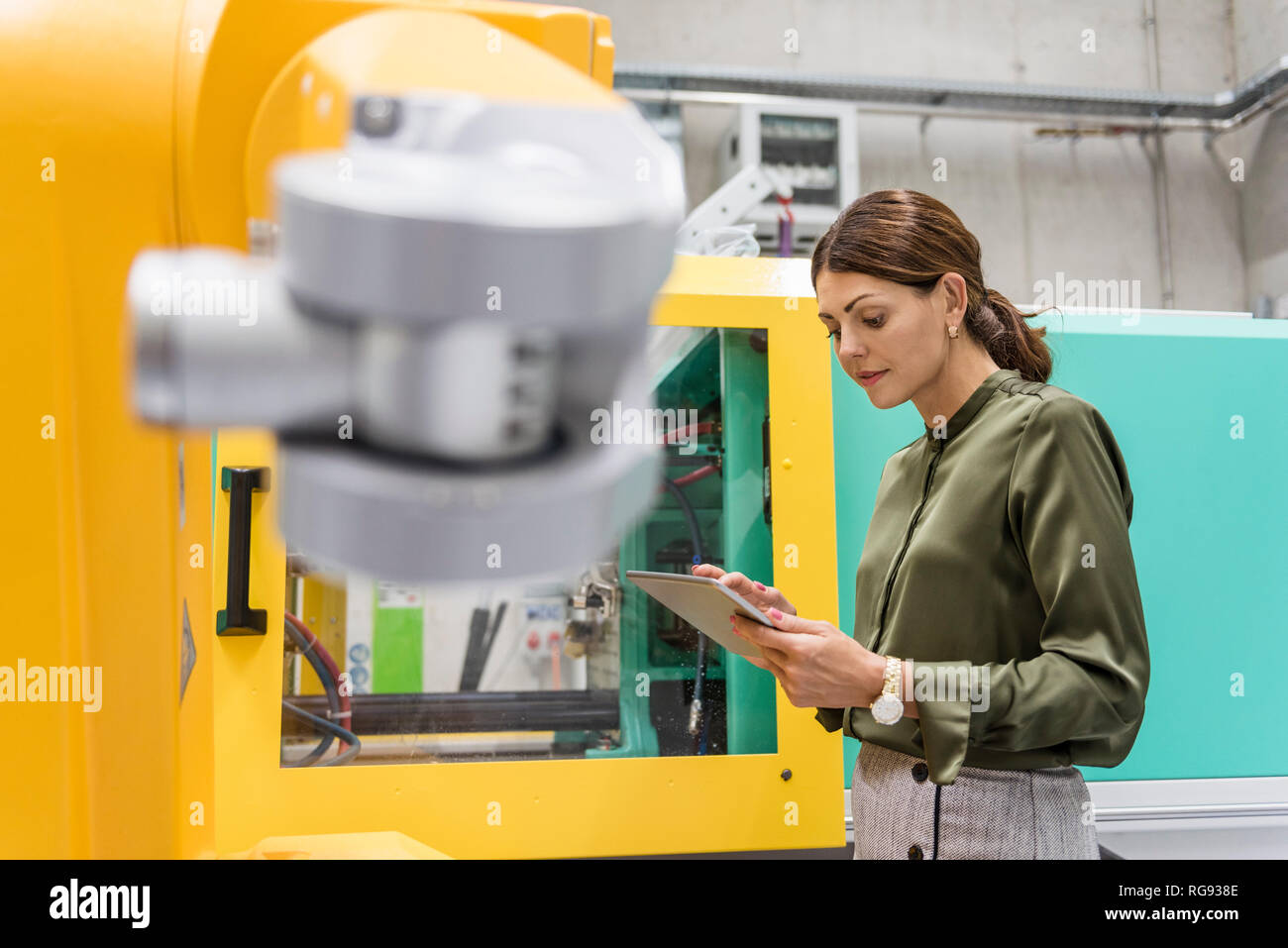 Geschäftsfrau Kontrolle Industrieroboter in High-Tech-Unternehmen Stockfoto