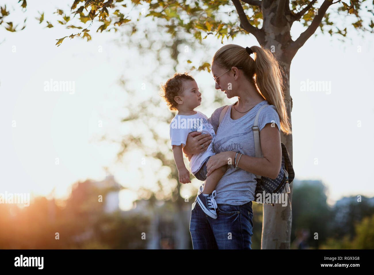 Mutter mit ihrem kleinen Sohn im Freien bei Sonnenuntergang Stockfoto