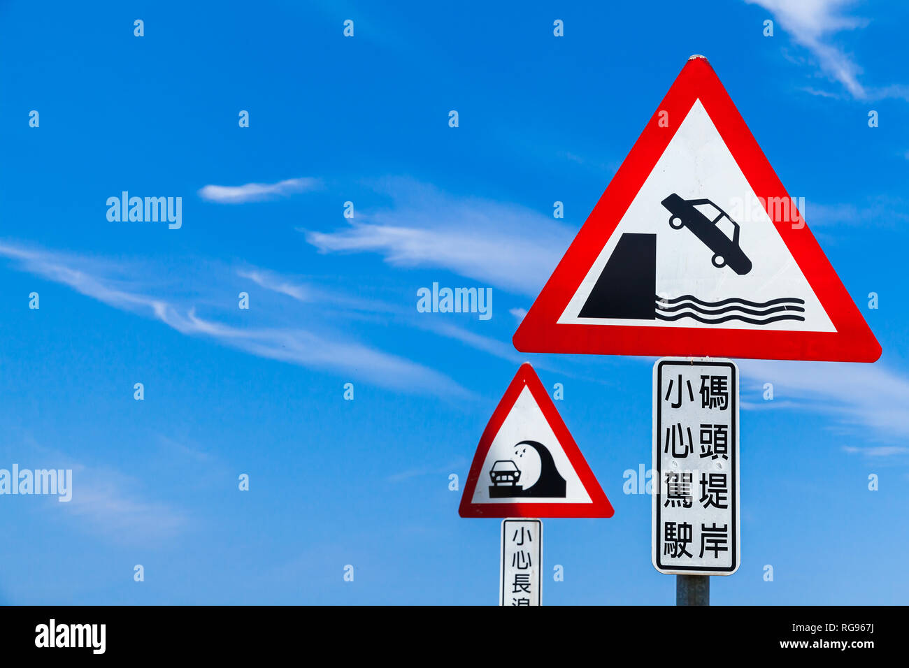 Vorsicht chinesische Straßenschilder unter blauem Himmel. Text Label bedeutet: Fahren Sie vorsichtig, Pier Damm Stockfoto