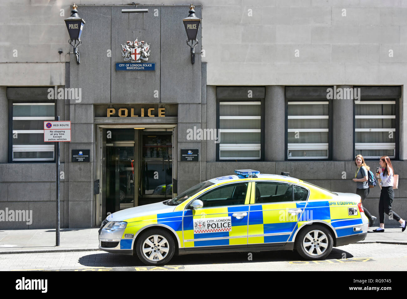 Street Scene zwei blaue Lichter über dem Eingang an der Außenseite von Bishopsgate der Londoner City Polizeistation mit Polizei Streifenwagen außerhalb von England UK geparkt Stockfoto