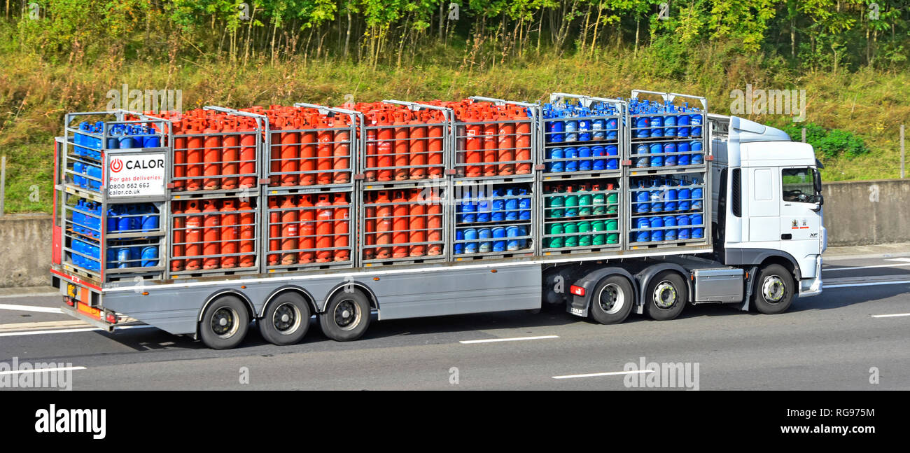 Seitenansicht der Lieferkette der Marke Calor Gas: Lkw und Gelenkanhänger mit Flaschen-Butan- und Propangasflaschen auf der britischen Autobahn Stockfoto
