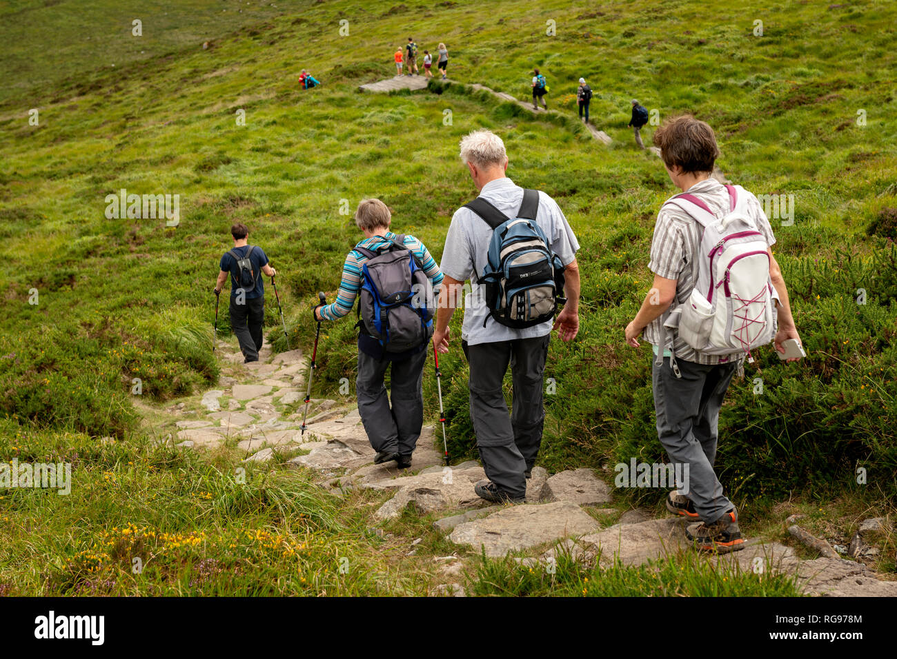Irland Wandern. Große Gruppe von Touristen, die auf einem Boardwalk Fußweg hinunter einen Bergpfad am Torc Berg, Grafschaft Kerry, Irland wandern. Stockfoto