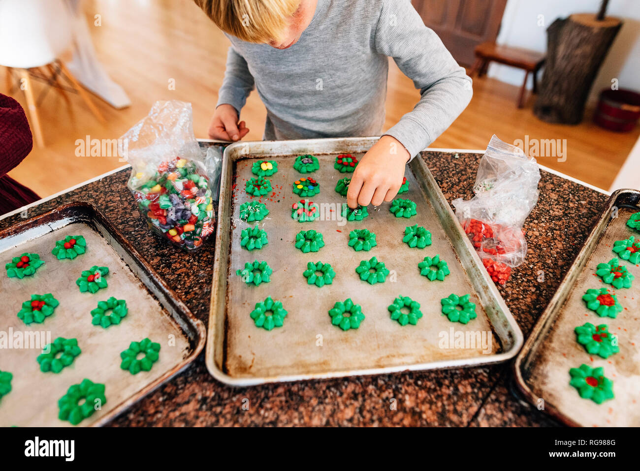 Junge in der Küche dekorieren Cookies Stockfoto