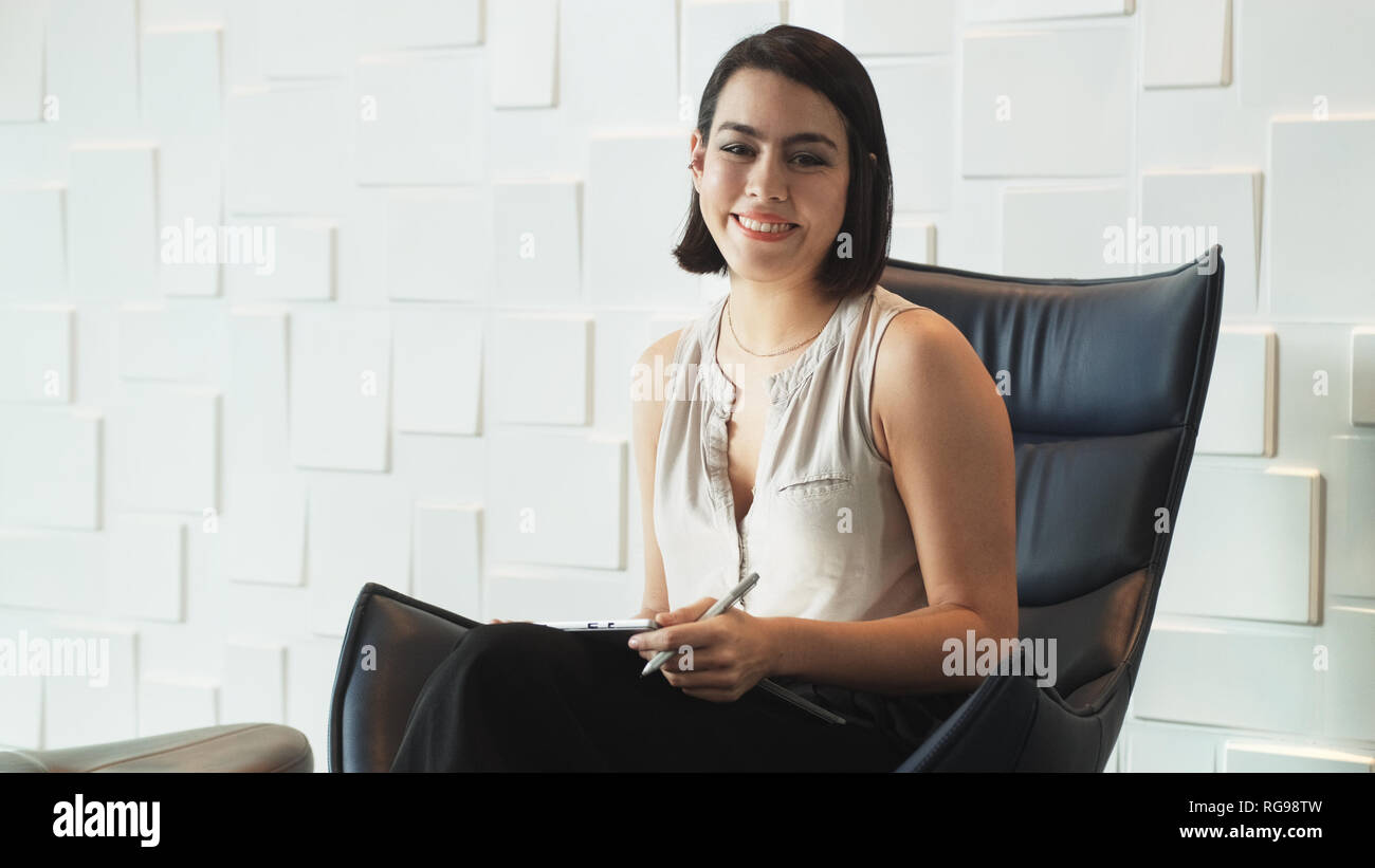 Happy Business Frau an der Kamera lächelnd im Büro Wartezimmer Stockfoto