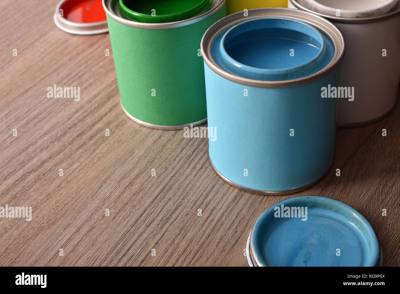 Sortiment öffnen Farbdosen und ihre Abdeckungen auf Holztisch, Erhöhte Ansicht. Horizontale Komposition. Stockfoto