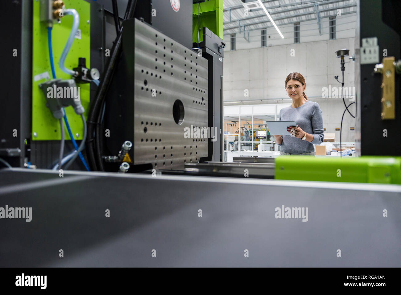 In High-Tech-Unternehmen, das Maschinen zur Herstellung von Geschäftsfrau, mit digitalen Tablet Stockfoto