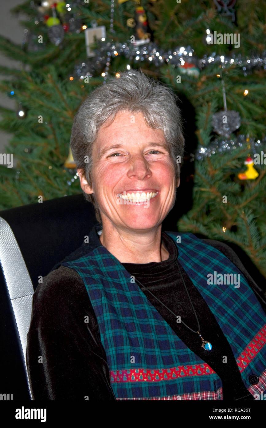 Frau; Portrait; breite Lächeln; ergrautes Haar; Weihnachtsbaum; Fröhlich; Attraktiv, vertikal; HERR Stockfoto