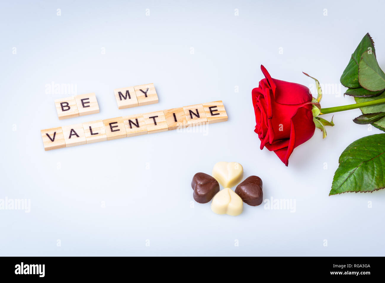 My Valentine mit Rot Rose auf weißem Hintergrund und vier Schokolade Herzen Stockfoto