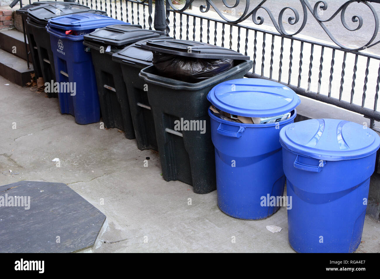 Müll und Recycling Bins Vor Gebäude am Bürgersteig Stockfoto