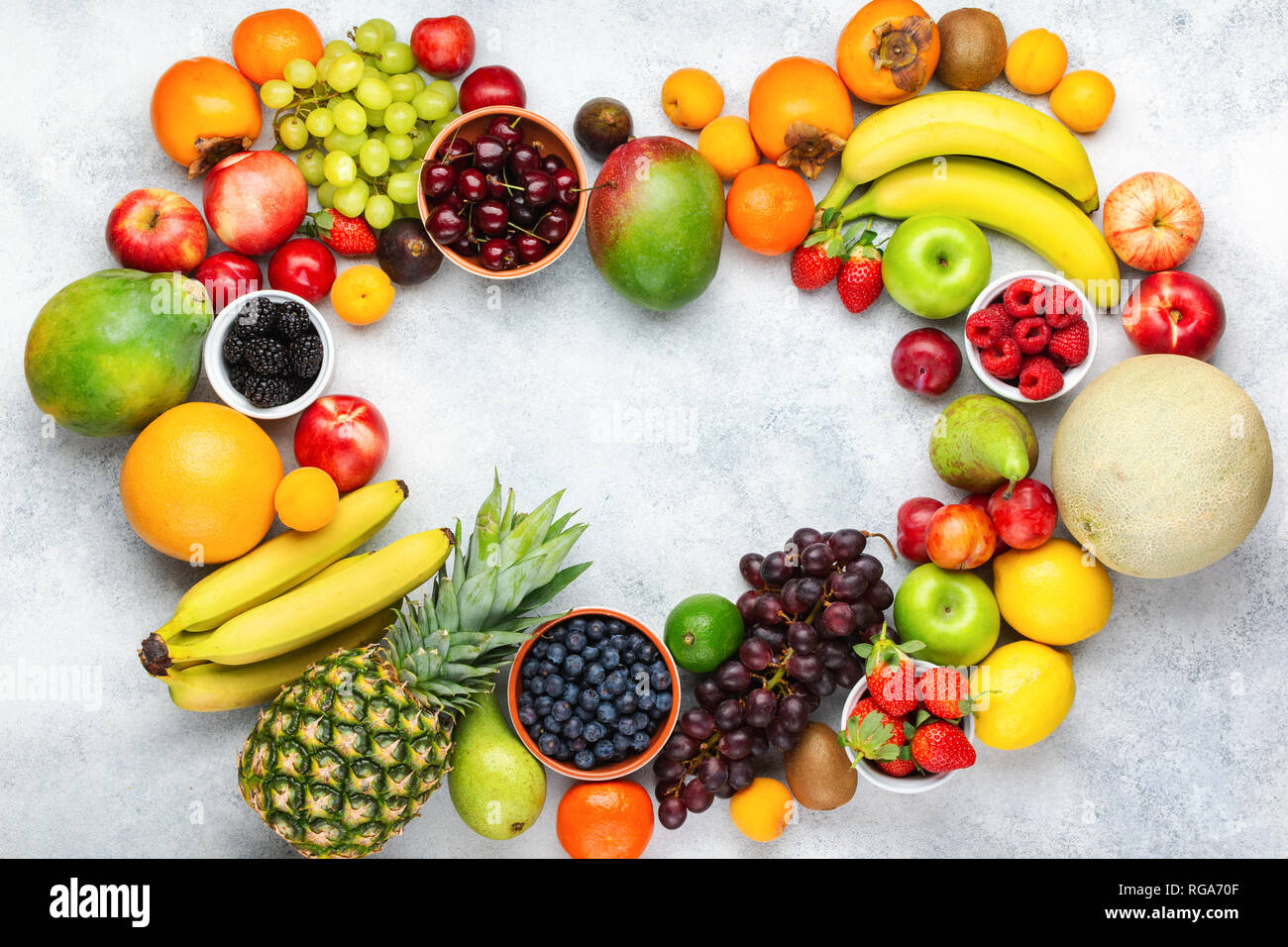 Herz aus gesunden bunten Früchten, Pflaumen Erdbeeren Himbeeren Orangen, Äpfel, Kiwis, Weintrauben, Heidelbeeren mango Kaki Ananas auf die Weiße Stockfoto
