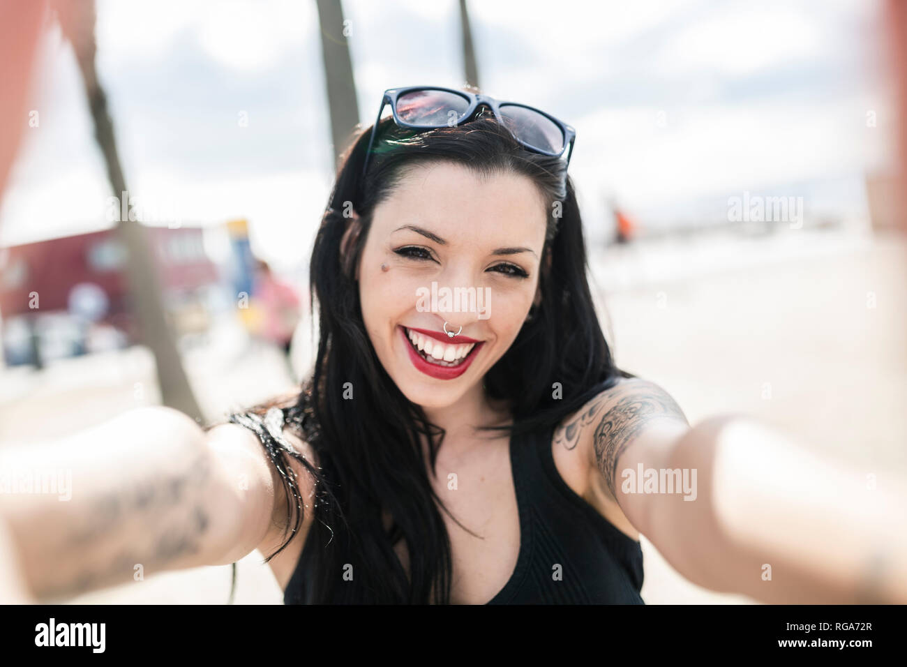 Porträt der glückliche junge Frau mit Nasen Piercing und Tattoos Stockfoto