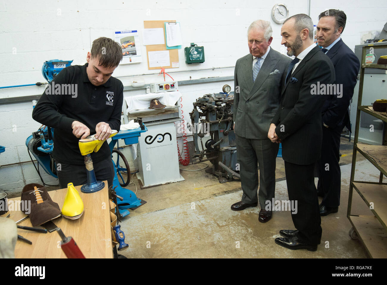 Der Prinz von Wales wird während einer Führung durch die Schaufabrik von Gaziano & Girling Ltd in Kettering den Prozess und die Schritte der Schuherstellung gezeigt. Stockfoto