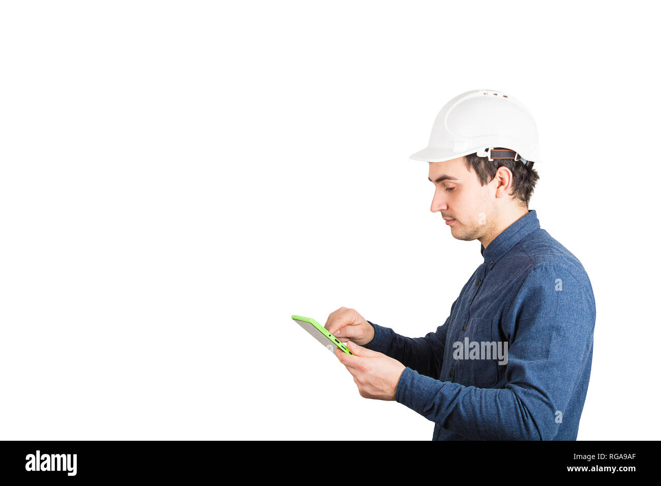 Seitenansicht ernster junger Mann Ingenieur tragen Schutzhelm mit einem Tablet Computer gadget Über weißen Hintergrund mit Kopie getrennt berechnen Stockfoto