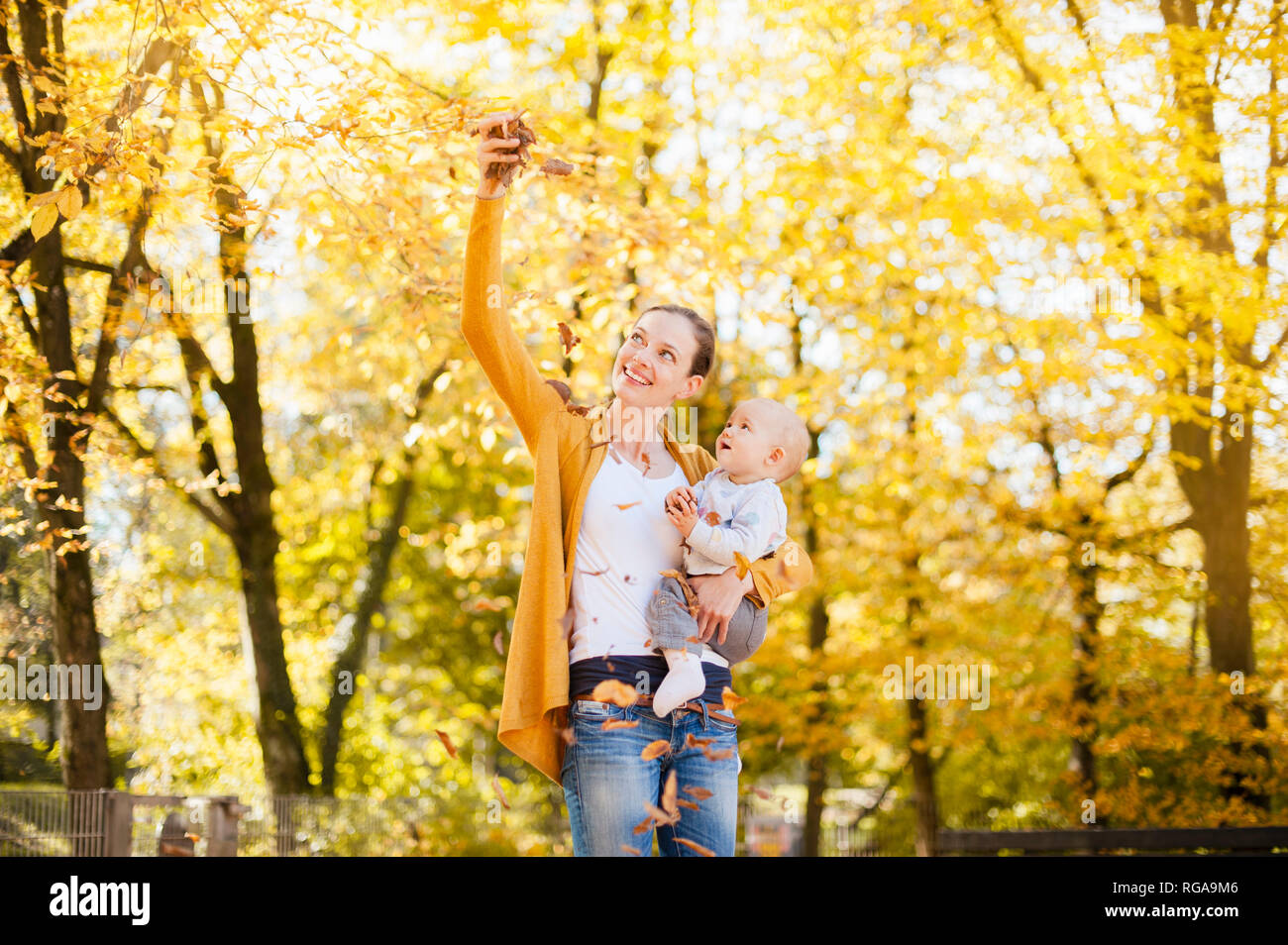 Mutter und Baby Mädchen Spaß mit Blätter im Herbst Stockfoto