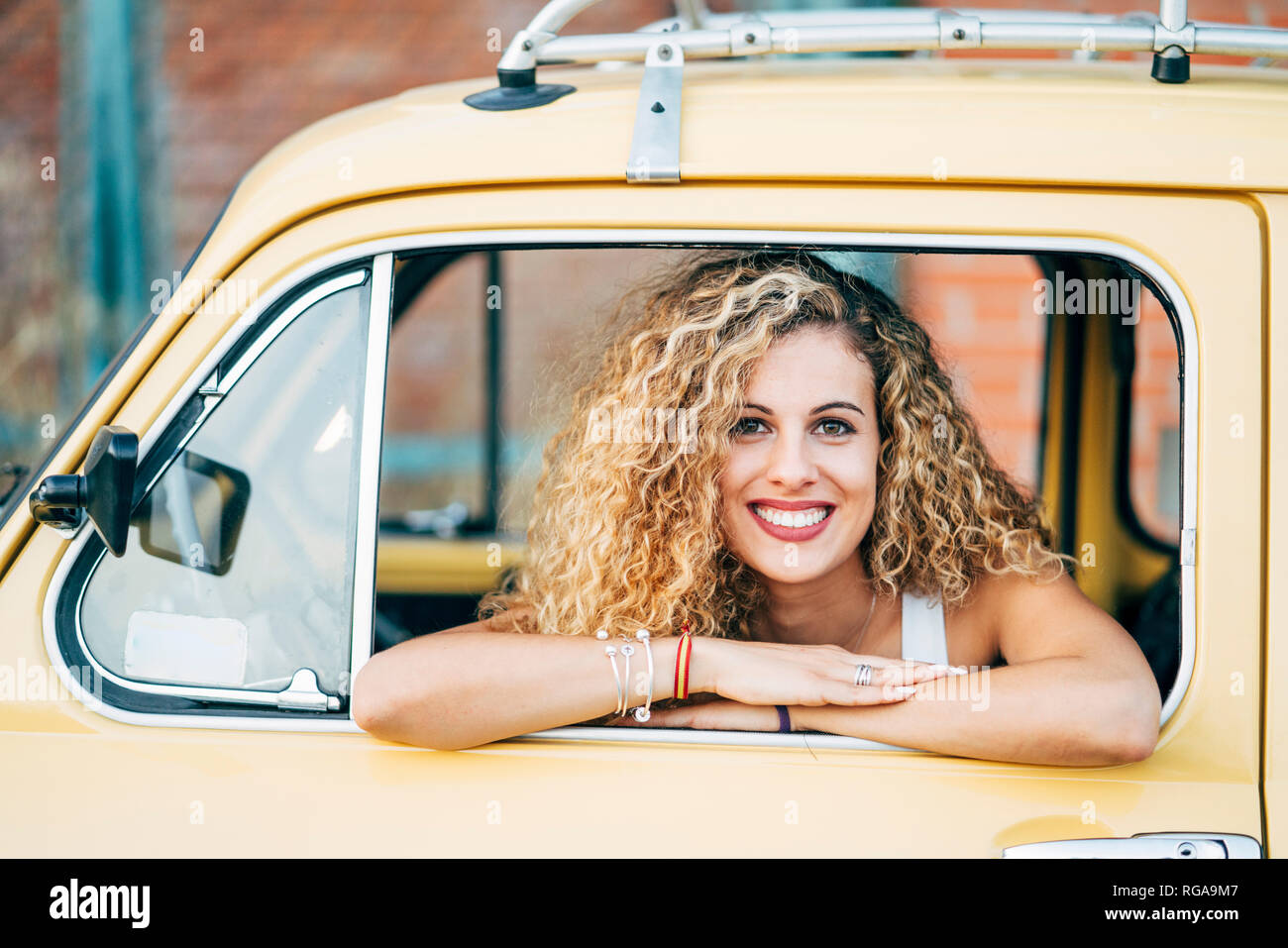Portrait von Happy blonde Frau aus dem Fenster der Classic Car suchen Stockfoto
