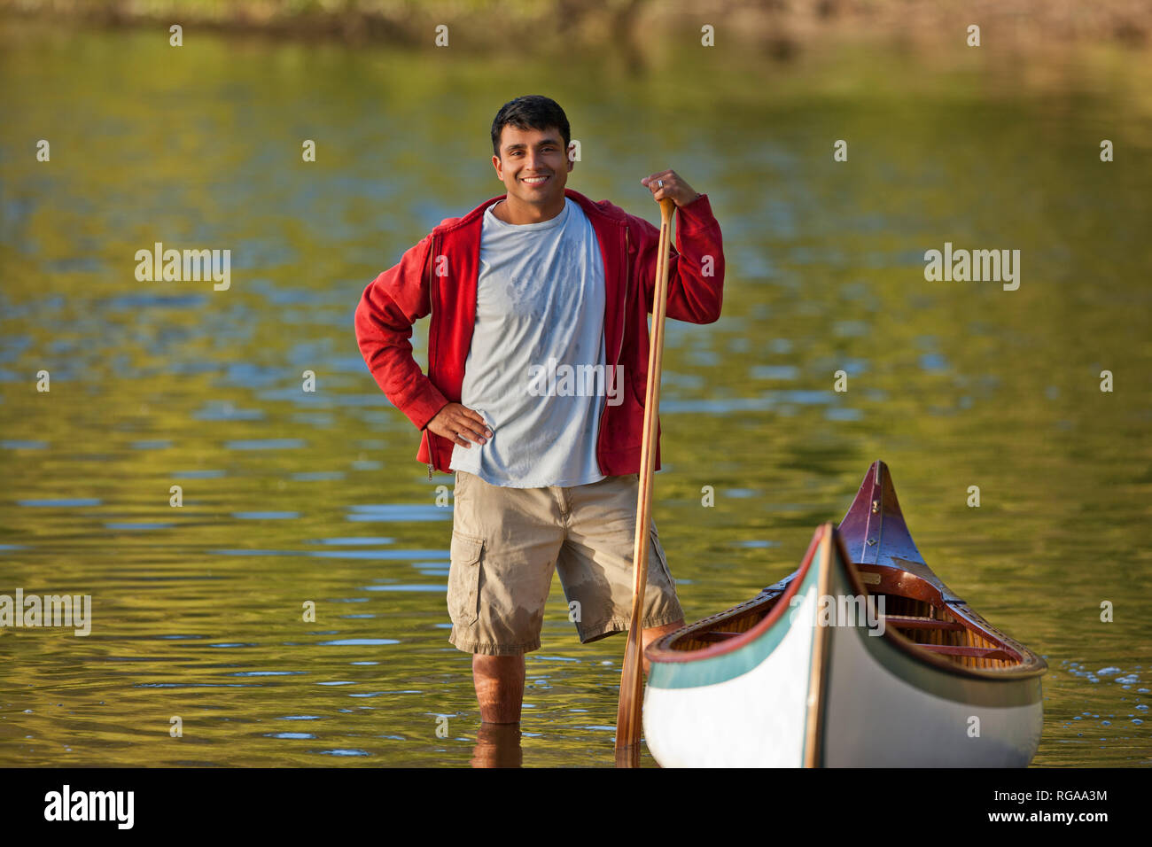 Porträt eines lächelnden Mann mittleren Alters am See mit seinem Kanu. Stockfoto