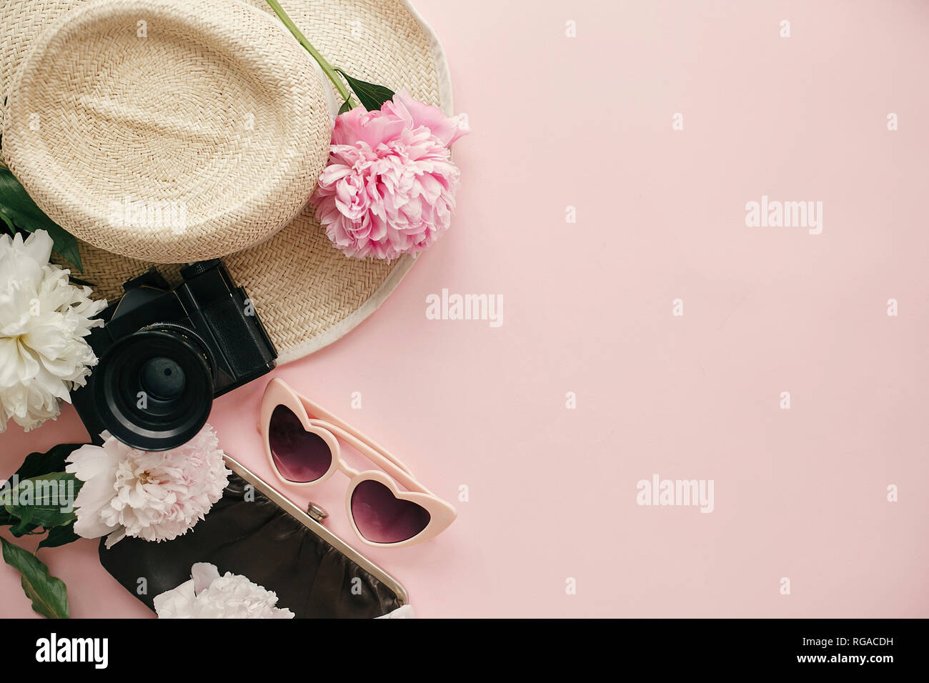 Internationaler Tag der Frau flach. Stilvolle girly Bild von Pfingstrosen, Fotokamera, retro Sonnenbrille, Hut, Geldbeutel auf Pastell rosa Papier mit kopieren. Stockfoto