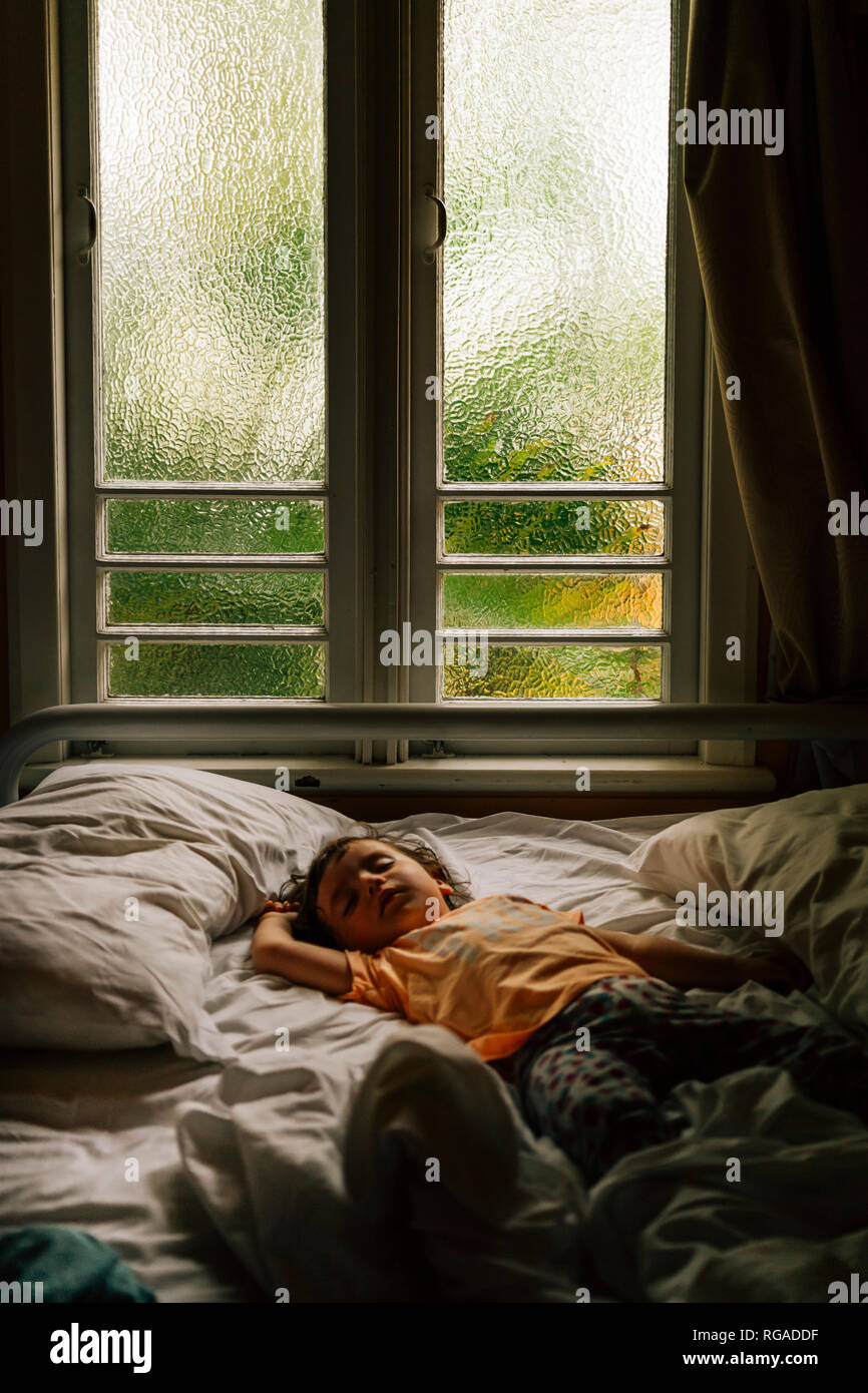 Baby schlafend auf dem Bett in den frühen Morgenstunden Stockfoto