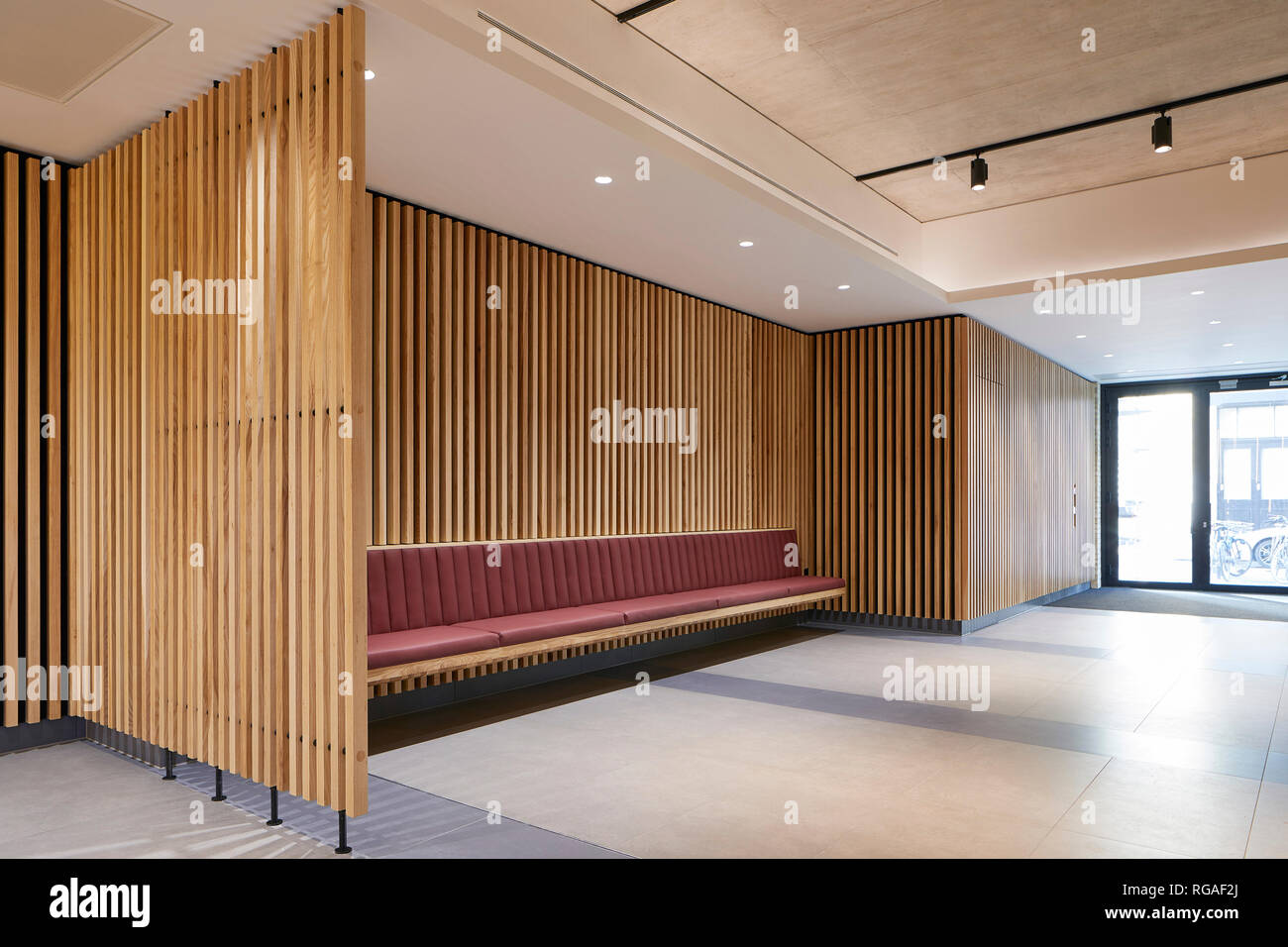 Holz vertäfelt und Partition mit Sitzbank im Rezeptionsbereich. Paul Street, London, Vereinigtes Königreich. Architekt: Steif+Trevillion Architekten, 2018. Stockfoto