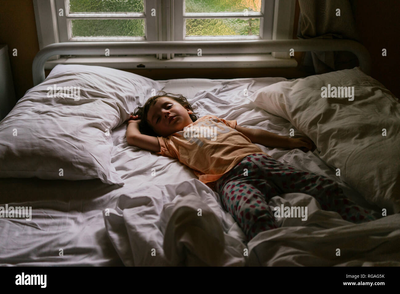 Baby schlafend auf dem Bett in den frühen Morgenstunden Stockfoto