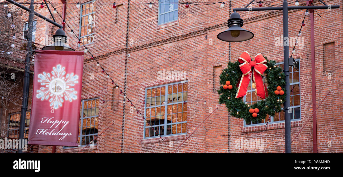 A Christmas wreath Dekoration hängen an einer Laterne im urbanen Raum. Stockfoto