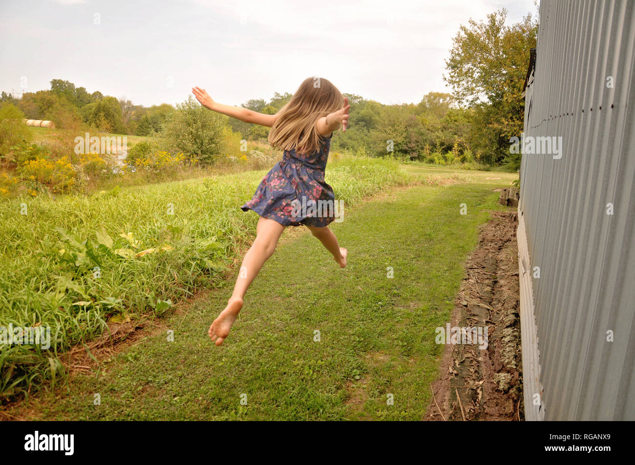 Mädchen in einem Kleid spielen im Land Stockfoto