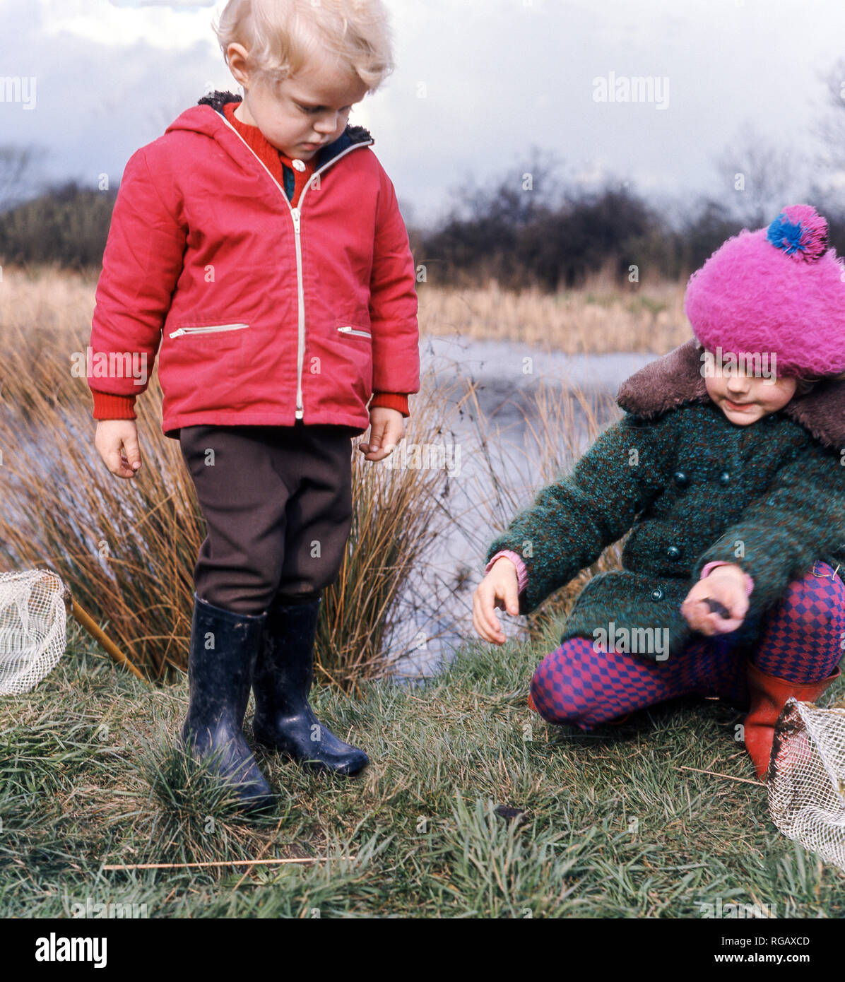 Zwei junge Kinder (ein Junge und ein Mädchen), die versuchen, einige Teich Tauchen im Naturschutzgebiet Attenborough in der Nähe von Tarporley Nottingham. Stockfoto