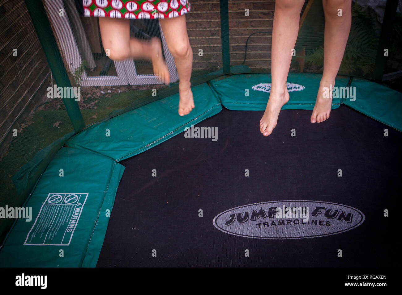 Zwei Mädchen spielen auf einem Garten Trampolin, nur einen Blick auf ihre Körper Stockfoto