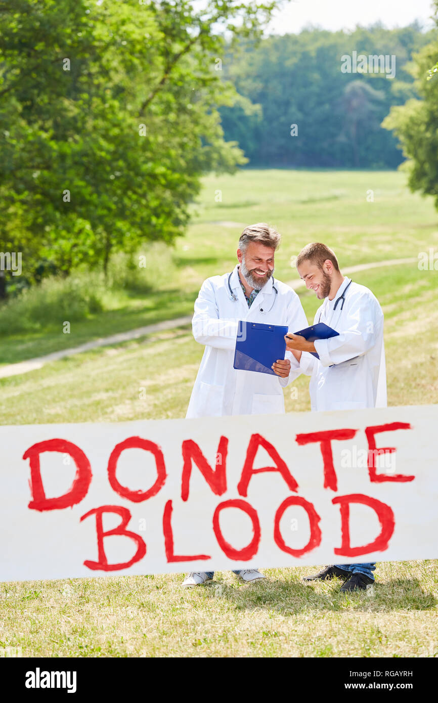 Zwei Ärzte als Aktivisten werben Spenden Blut für die Blutspende Stockfoto