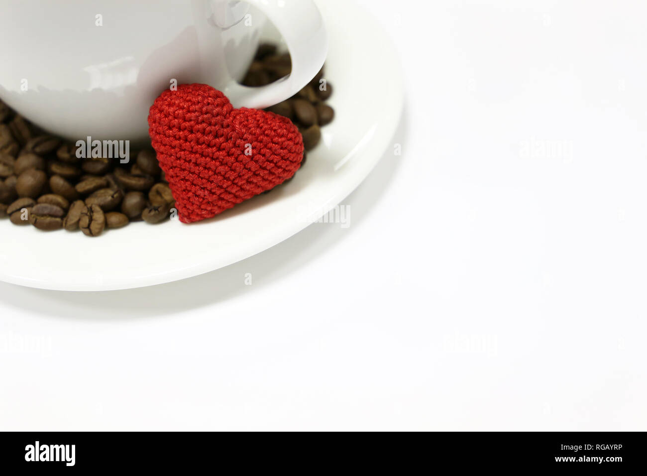 Romantisches Frühstück auf Valentinstag, Tasse Kaffee, Rot gestrickt, Herz und Kaffeebohnen isoliert auf Weiss. Konzept der Liebe, glückliche Morgen Stockfoto