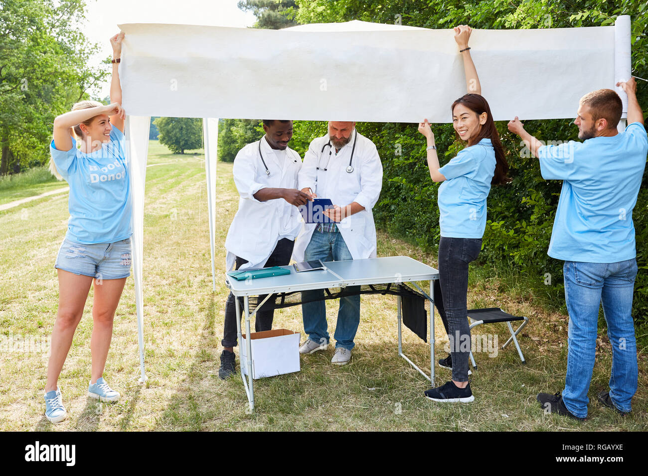 Freiwillige bauen einen Stand für die blutspende Aktion im Park Stockfoto