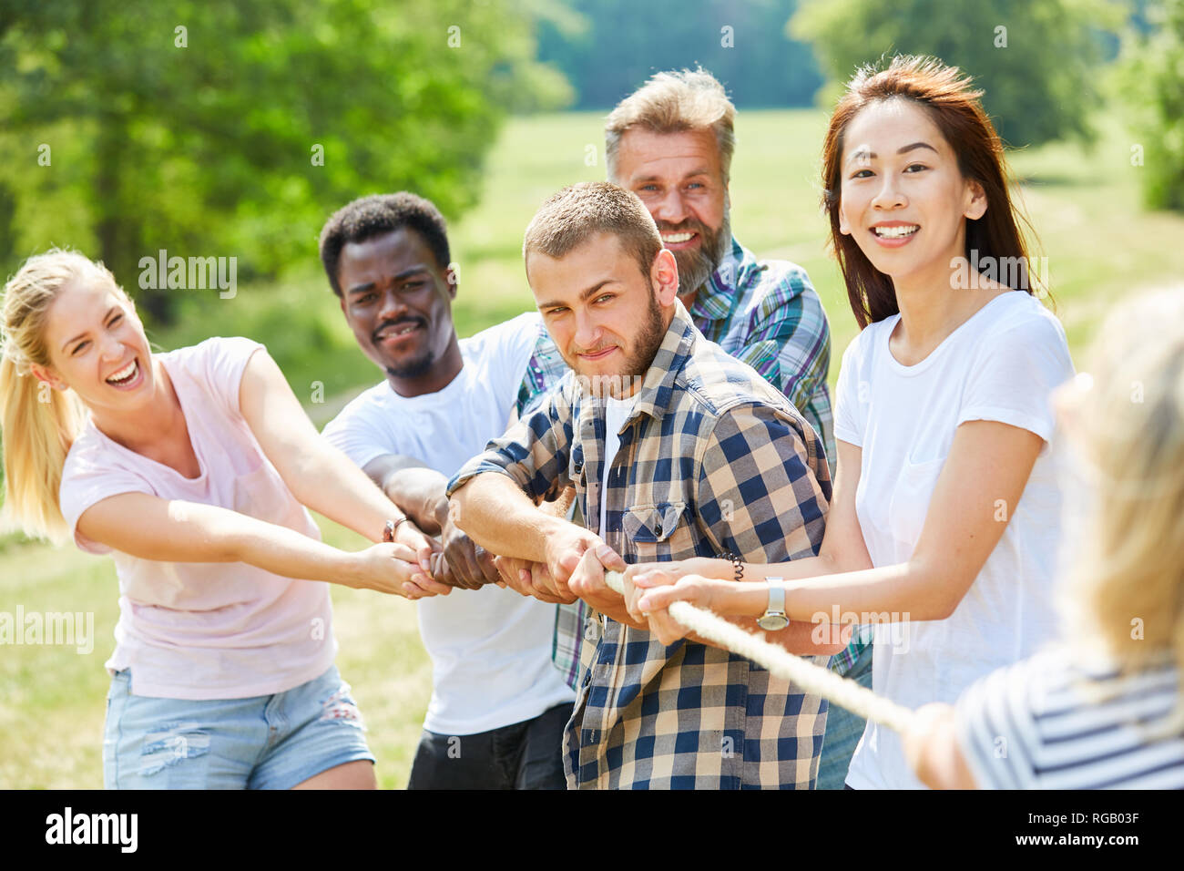 Gruppe von Jugendlichen zusammen in Tauziehen am Teambuilding workshop Stockfoto